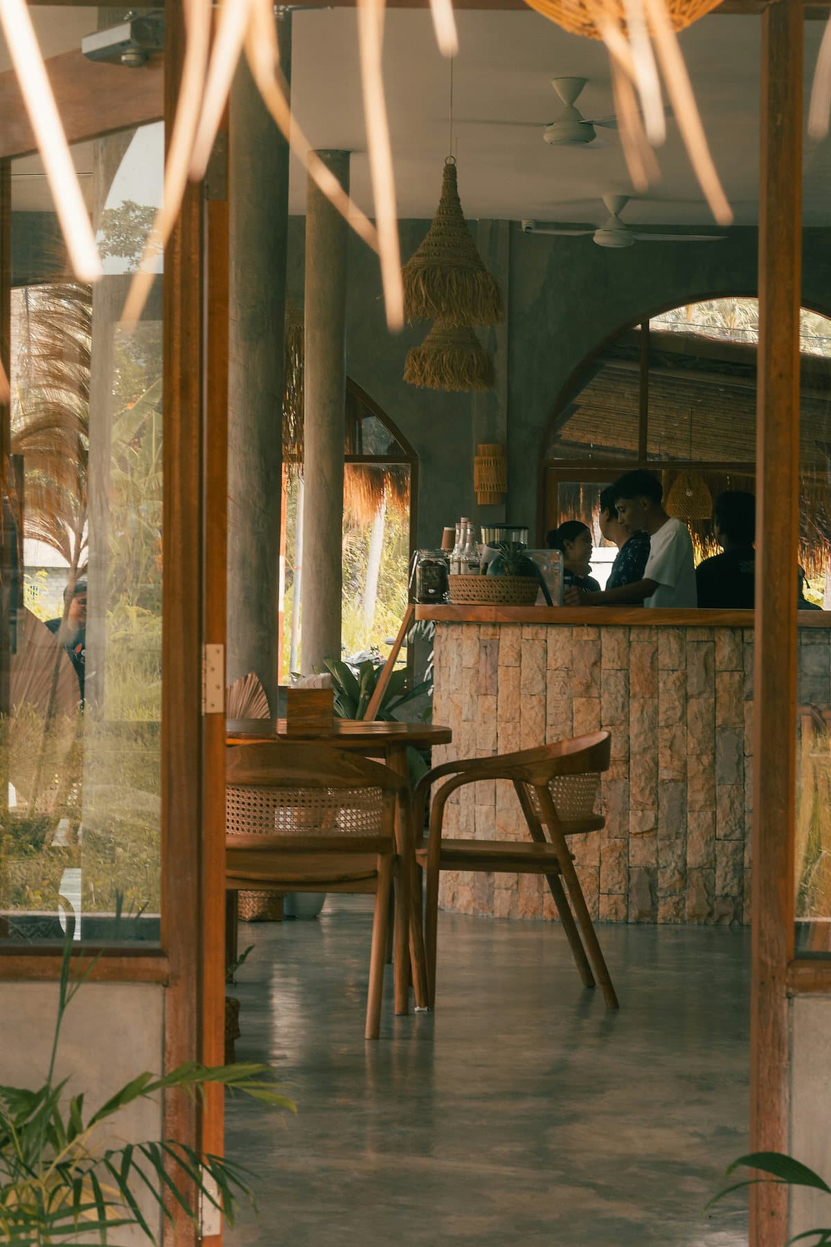 Interieur van een café in Amed met rieten lampen, houten stoelen en een stenen bar