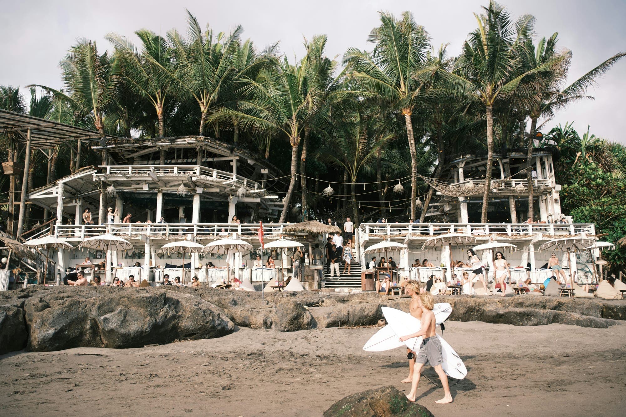 Strandtenten en beachclubs onder de palmen aan het strand van Canggu