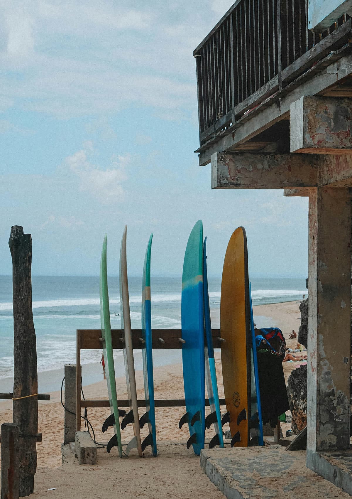 Gekleurde surfboards staan op een rek bij een verhuurpost aan het strand op Bali
