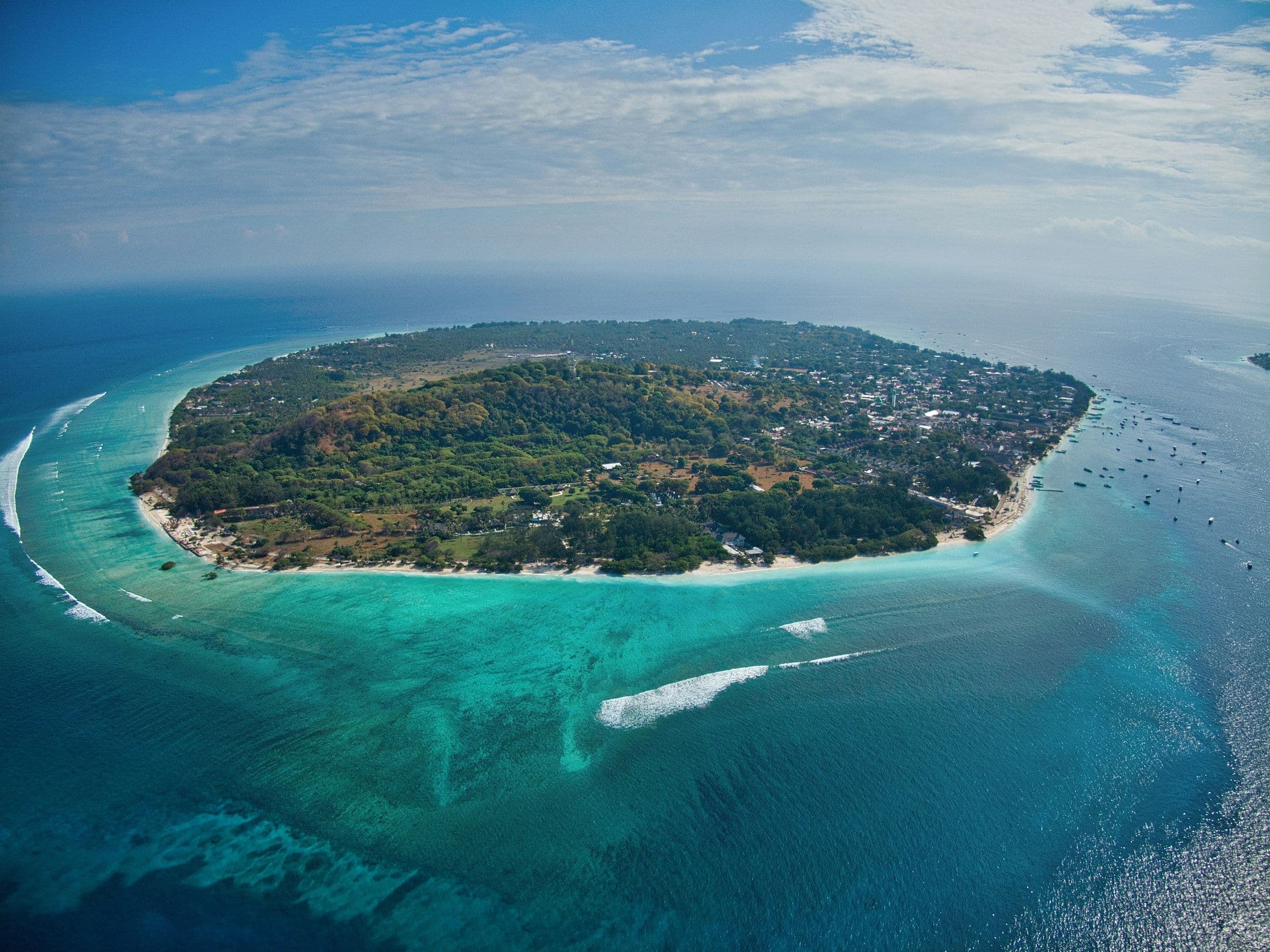Luchtfoto van het kleine eiland Gili Meno met wit strand, groen binnenland en een rif eromheen