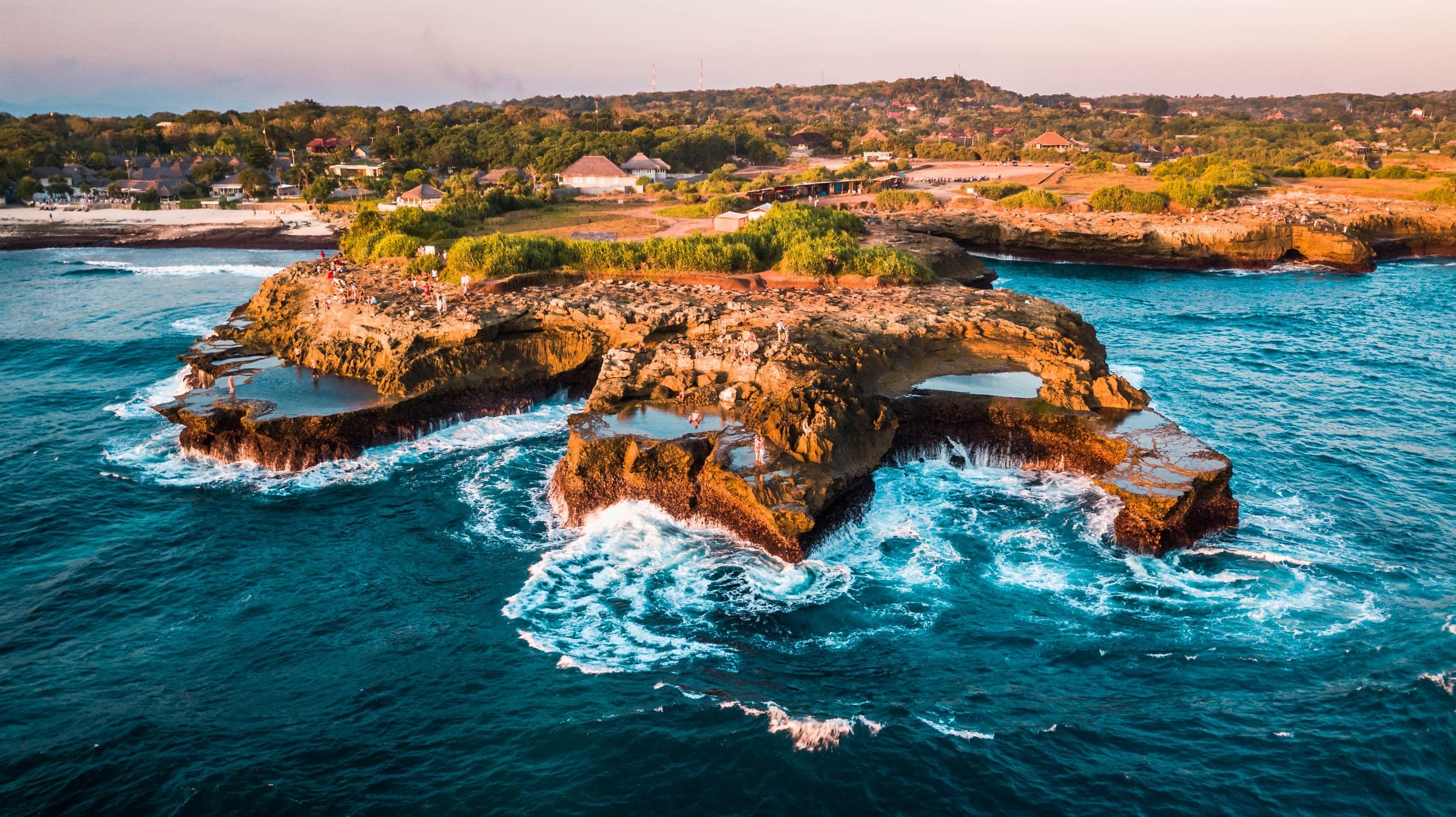 De golven slaan tegen het rotsplateau van Devil’s Tear op Nusa Lembongan