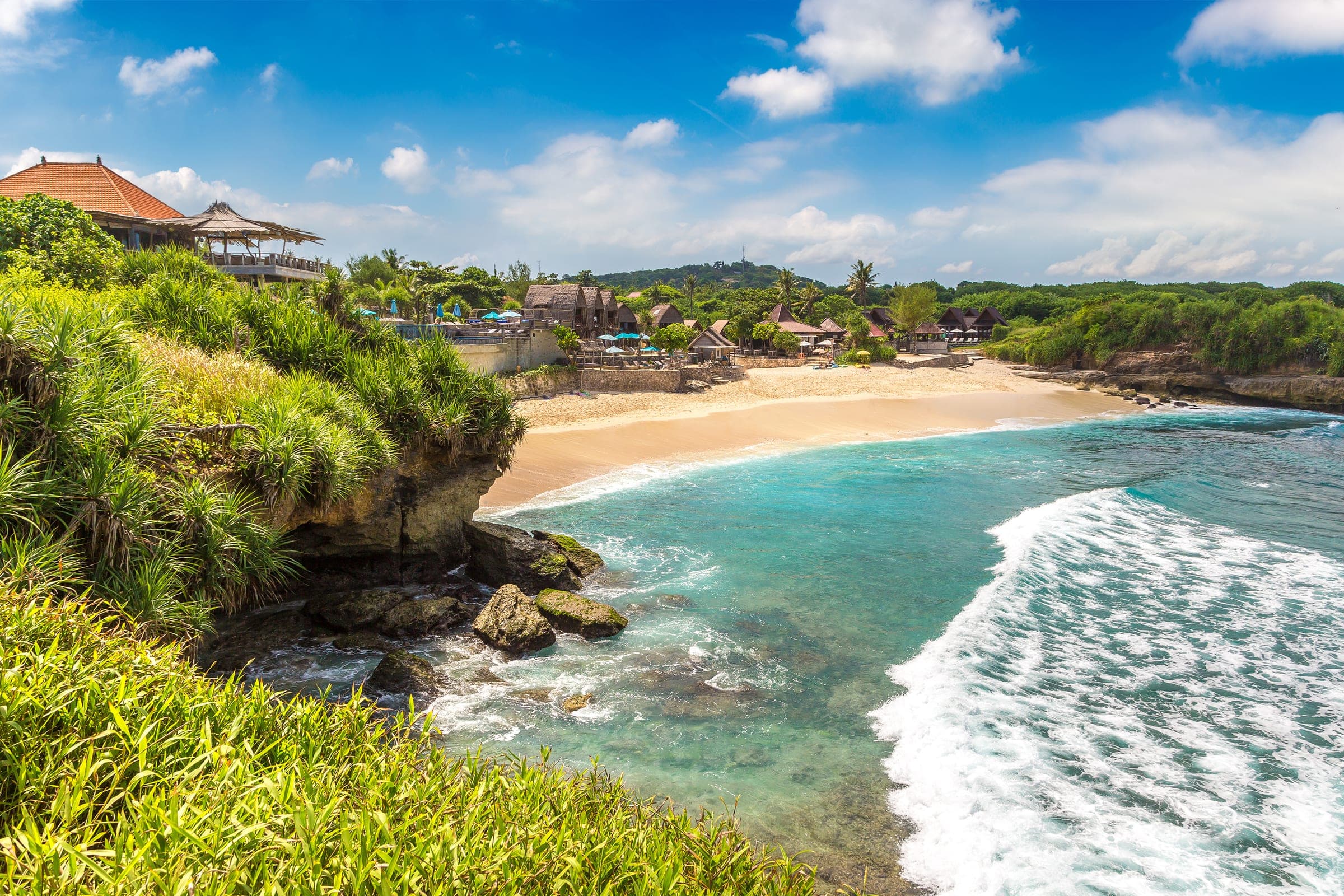 Een baai met wit zand, turkoois water en palmen aan de kust van Nusa Lembongan
