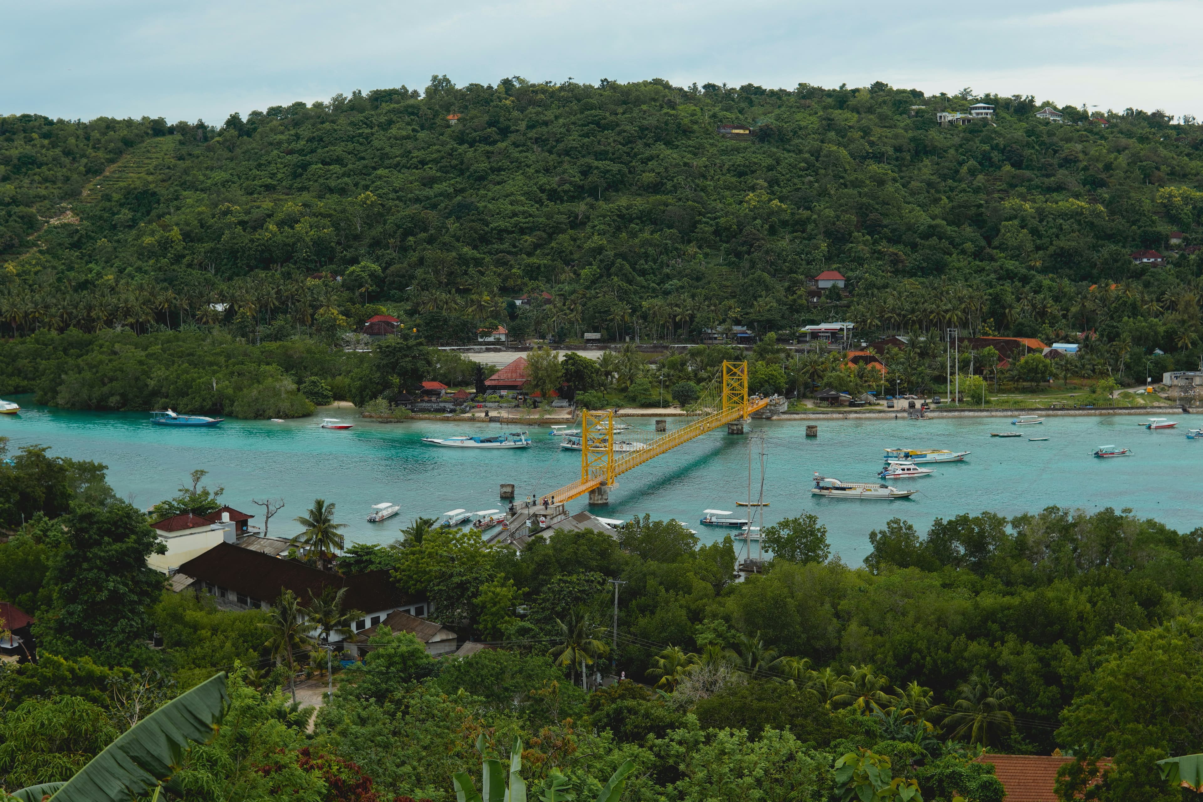 De gele hangbrug tussen Nusa Lembongan en Nusa Ceningan boven turkoois water