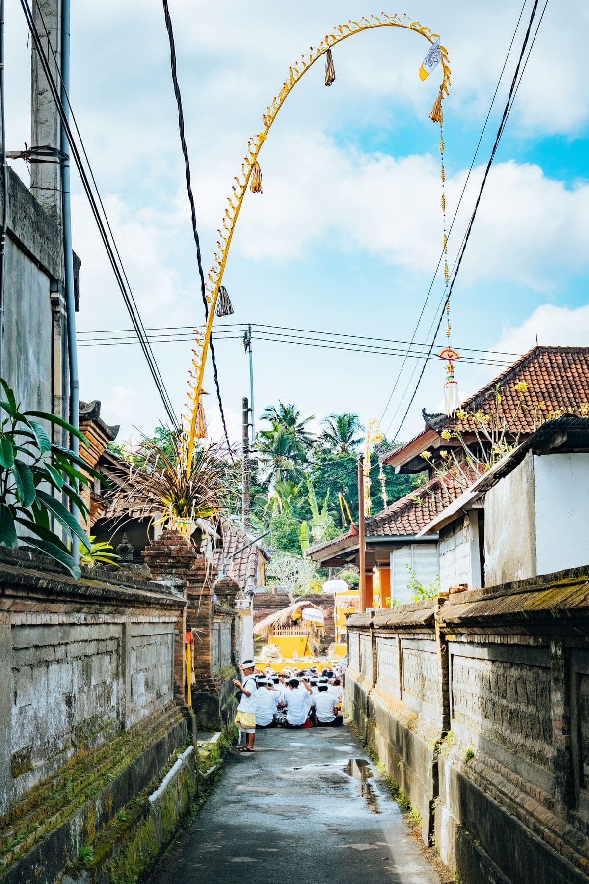Straatje in Ubud met winkeltjes, tempelpoortjes en bamboe versieringen langs de weg