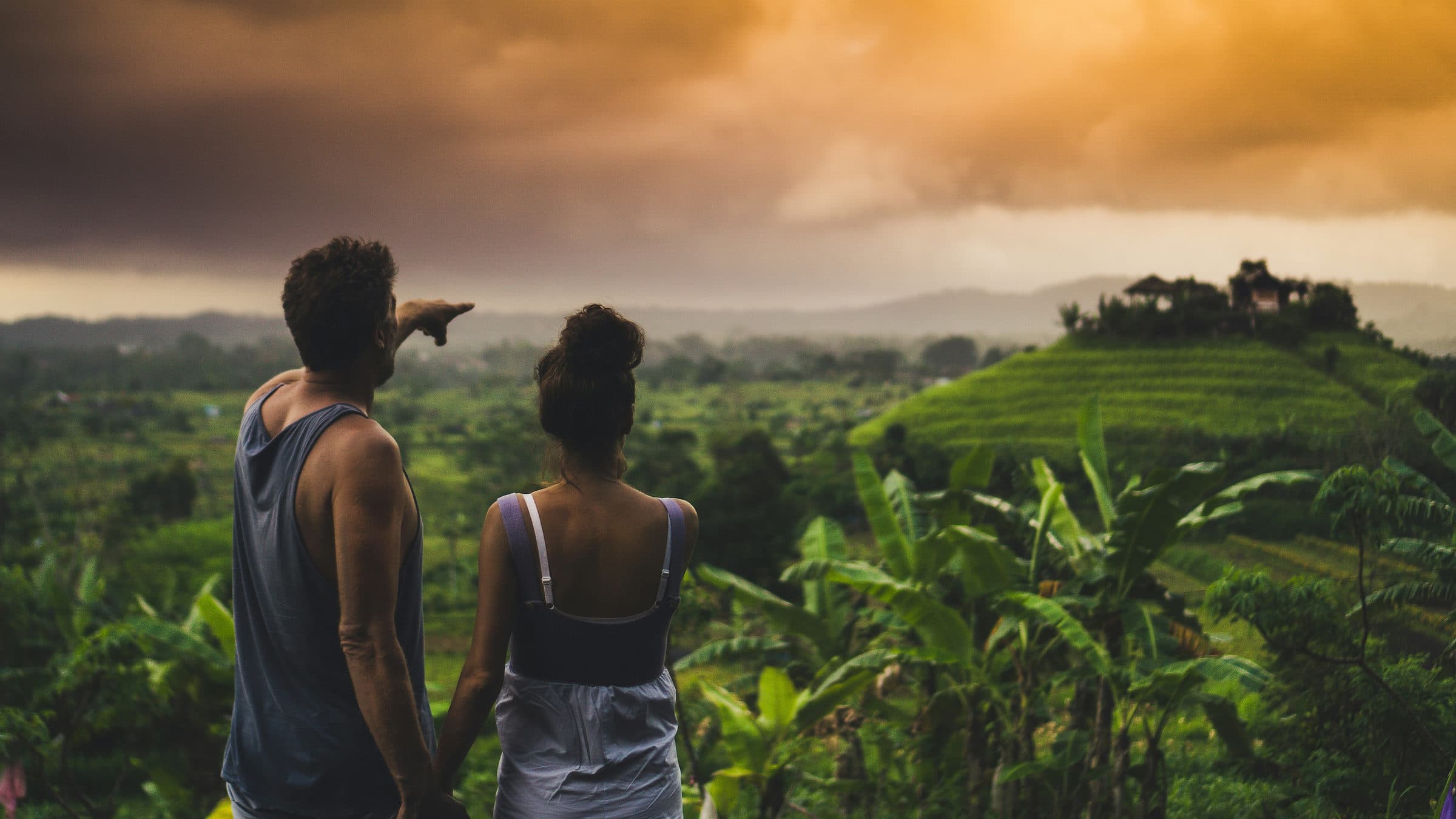 Twee reizigers kijken uit over de groene heuvels en rijstvelden van het binnenland van Bali