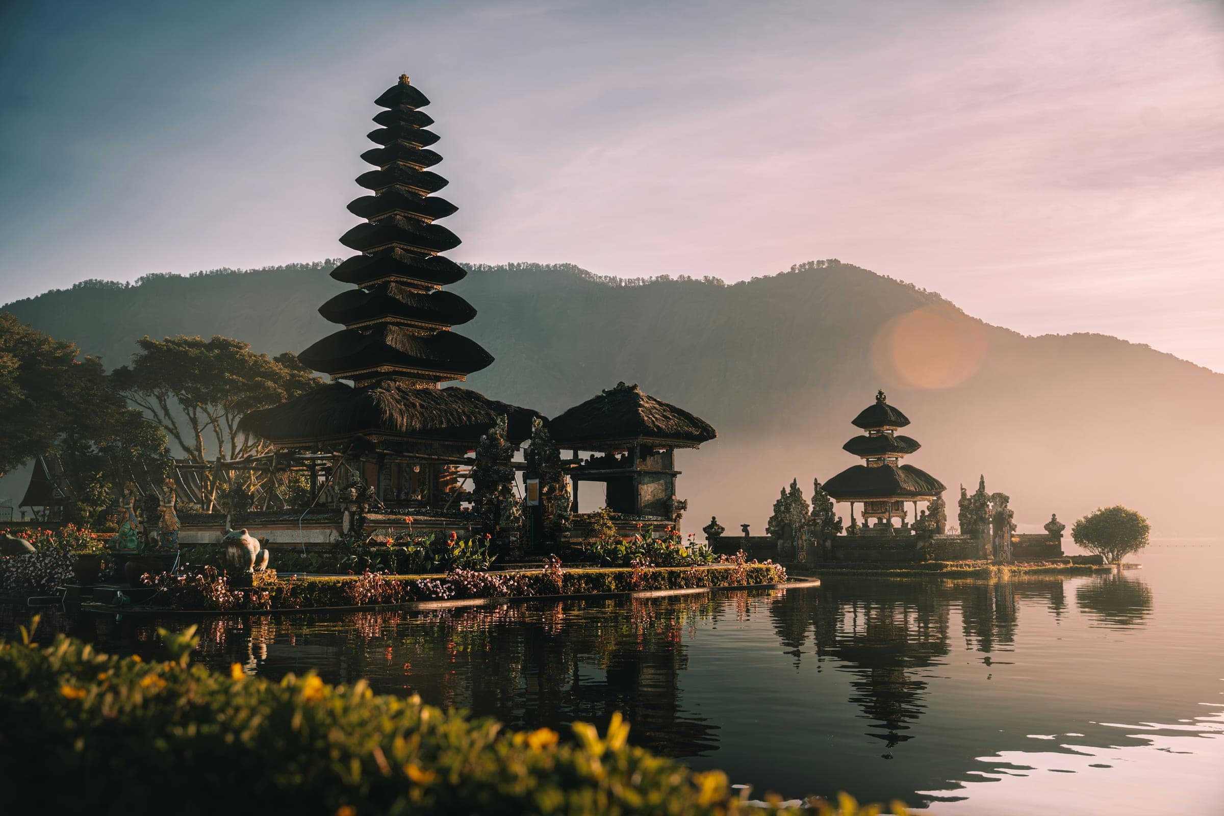 De Ulun Danu Beratan-tempel weerspiegeld in het meer bij zonsopkomst op Bali