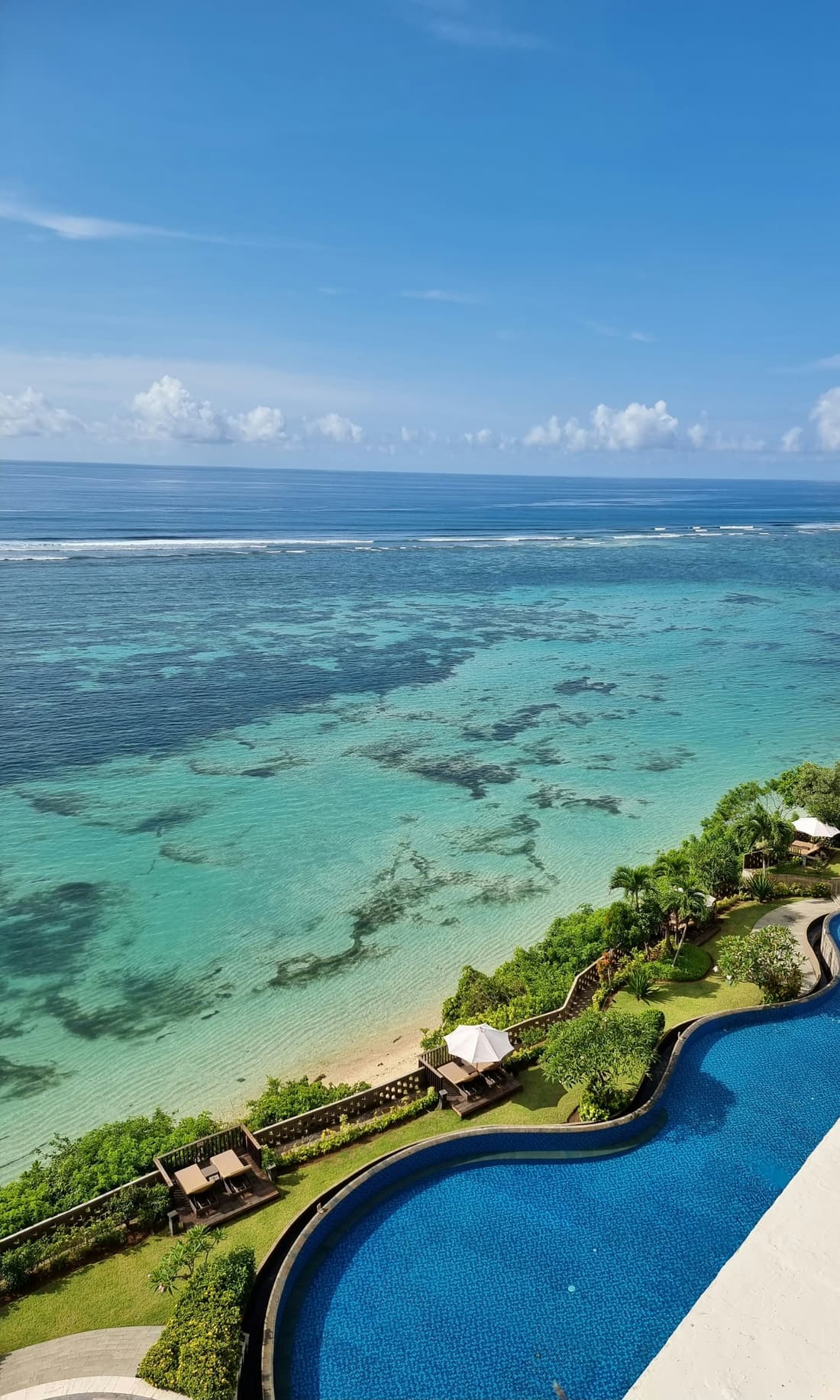 Uitzicht vanaf een klif over het ondiepe rif en de turkooizen zee bij Uluwatu