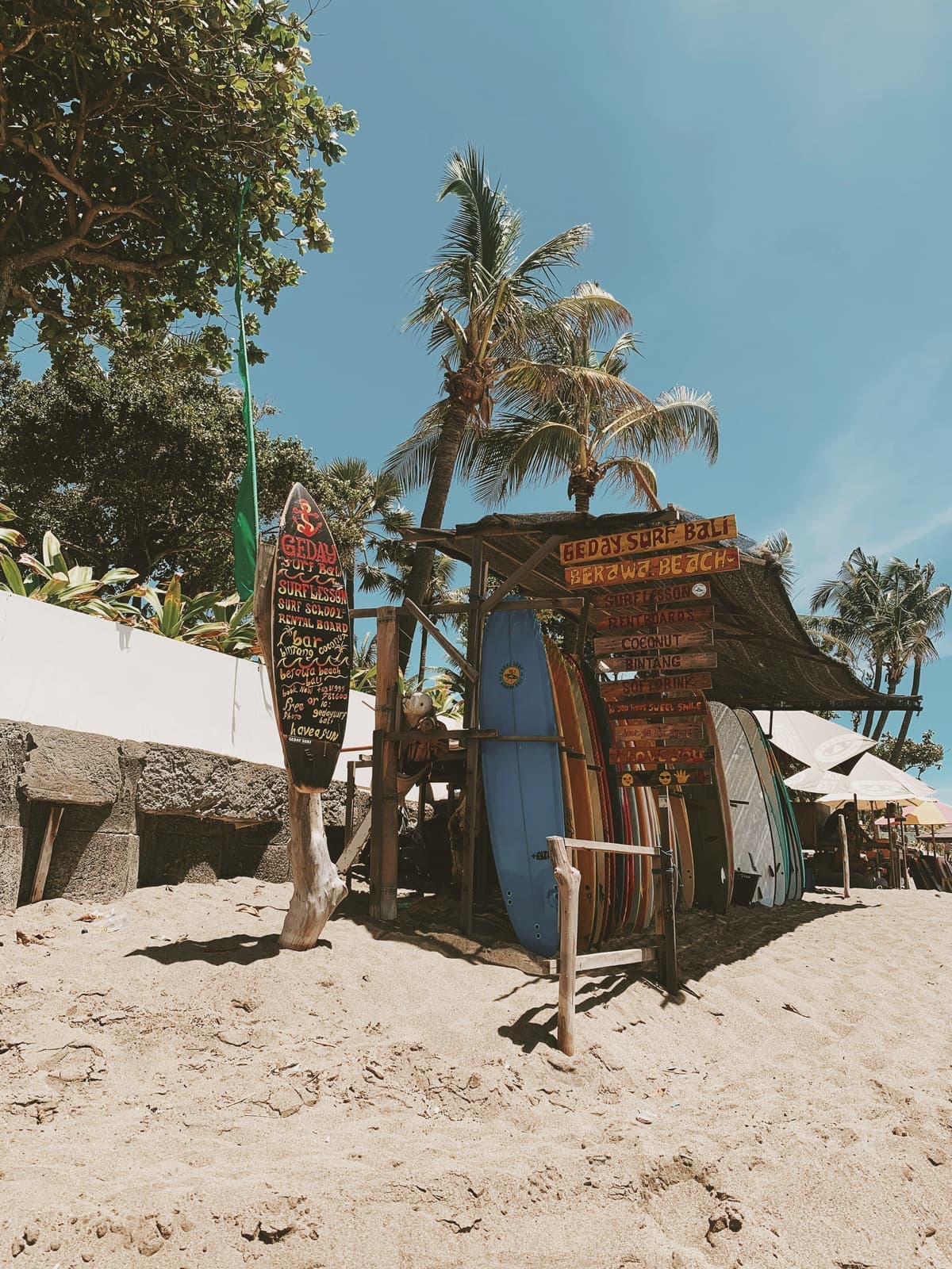 Surfplanken en borden bij een strandshop onder de palmen op Bali