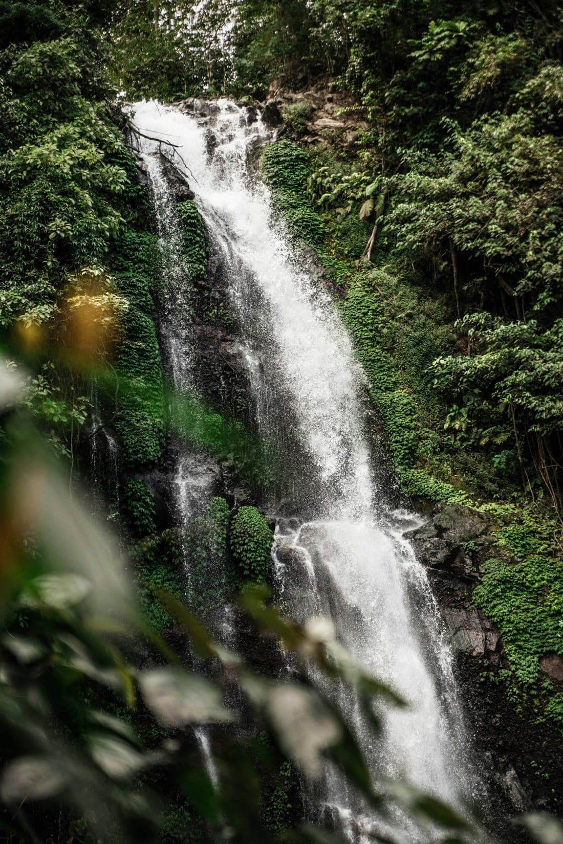 De Melanting-waterval bij Munduk stort tussen begroeide rotsen naar beneden