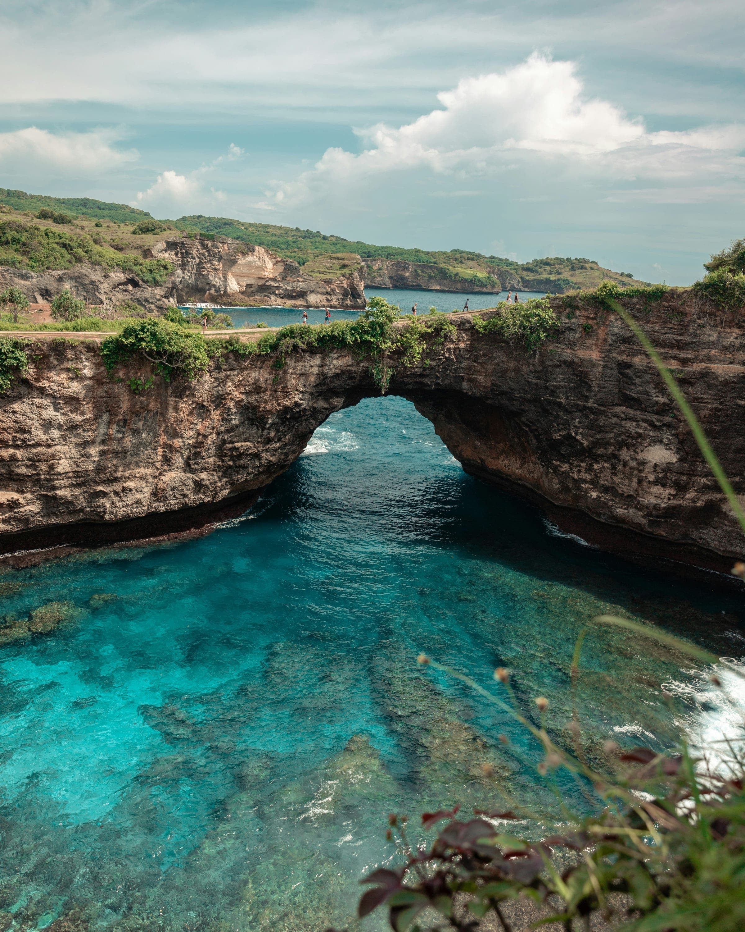 De natuurlijke rotsboog van Broken Beach op Nusa Penida boven blauwgroen zeewater