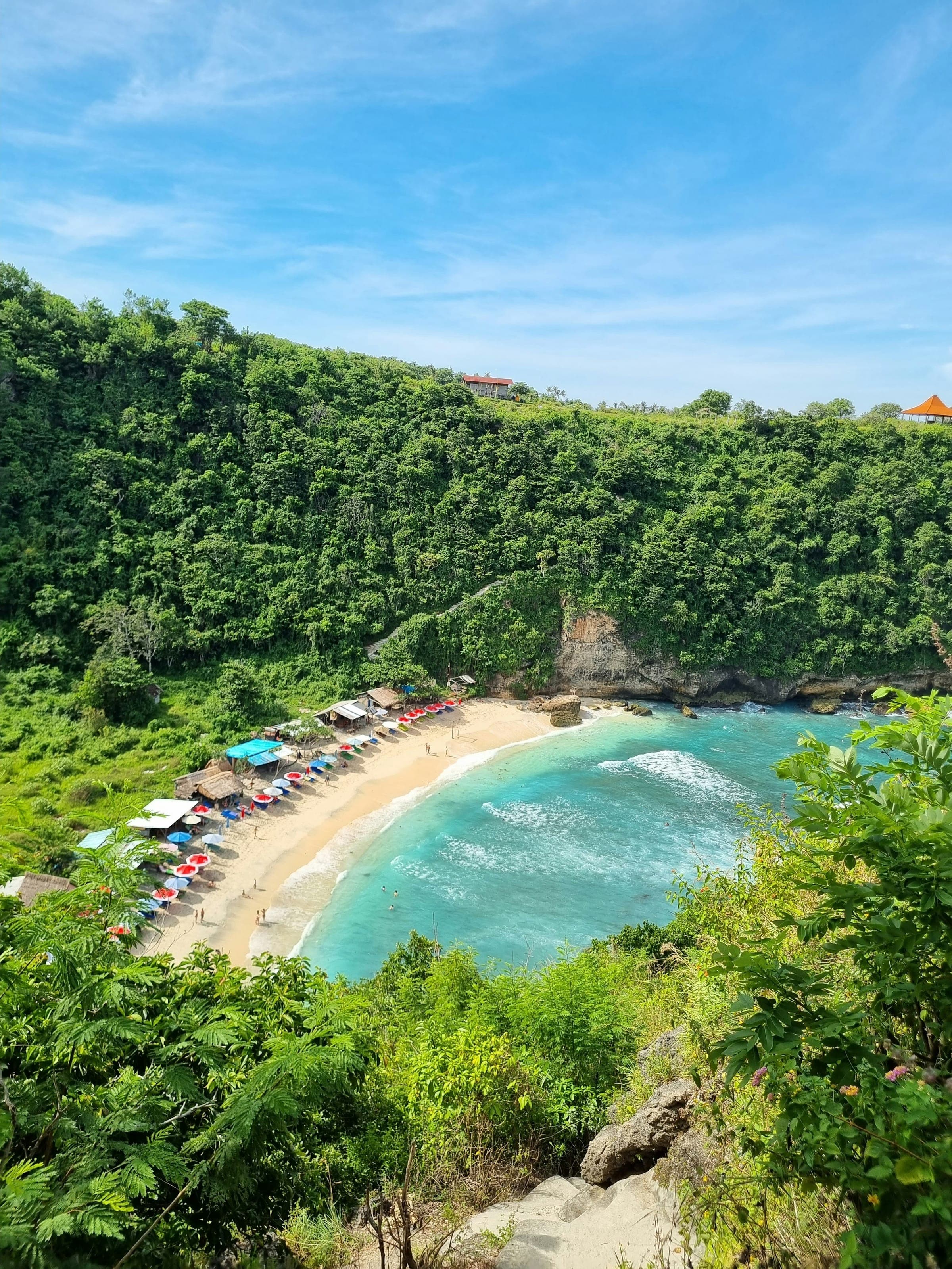 Crystal Bay op Nusa Penida met parasols op het strand en jungle tot aan de waterlijn