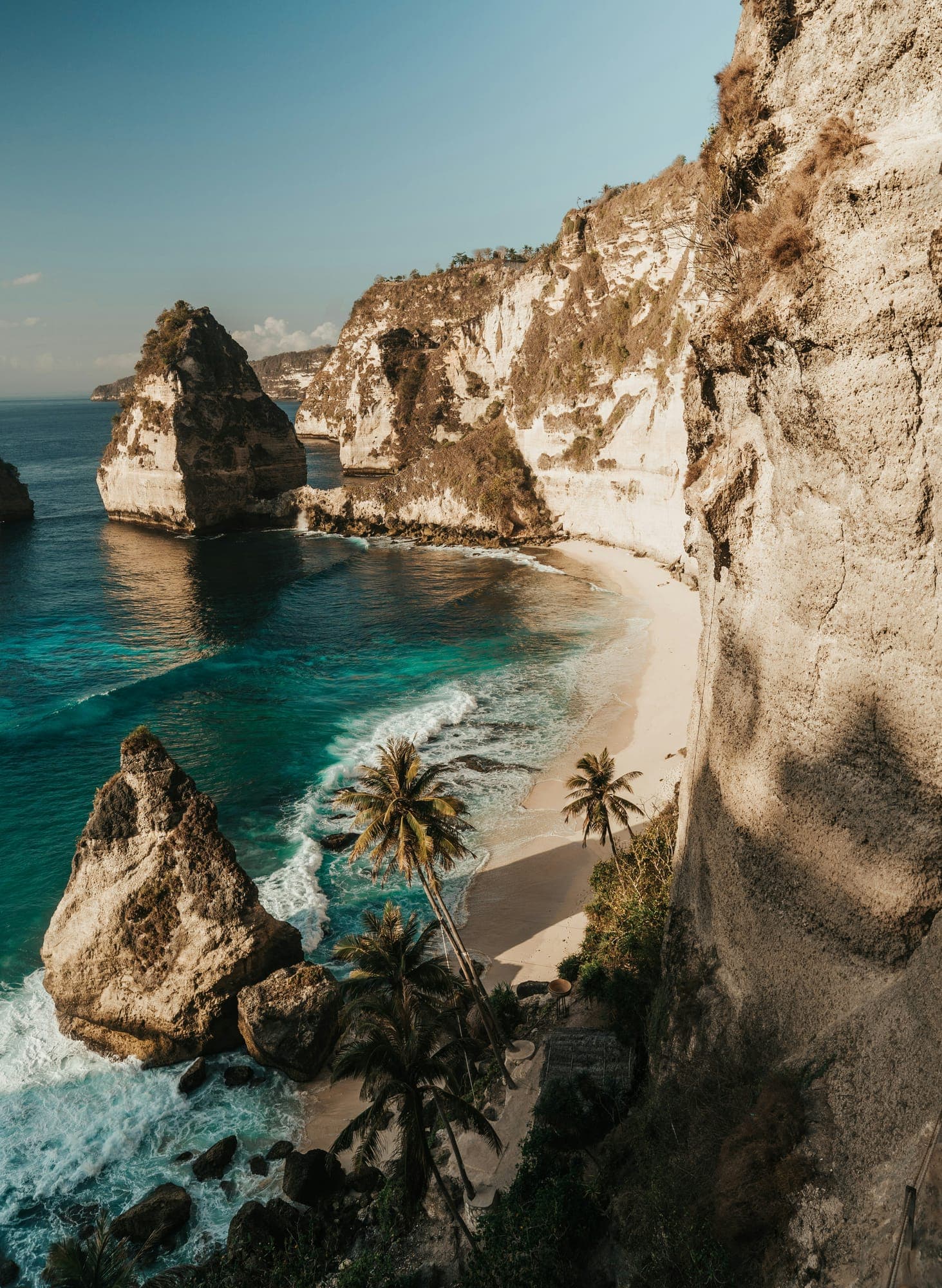 Diamond Beach op Nusa Penida met witte rotspunten, palmen en helder turkoois water