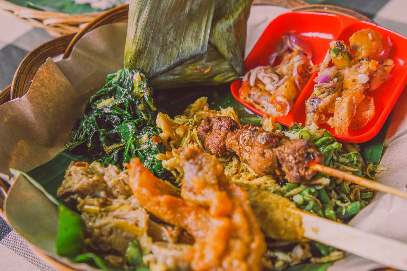 Verschillende Balinese schotels naast elkaar in mandjes en bakjes op een marktkraam